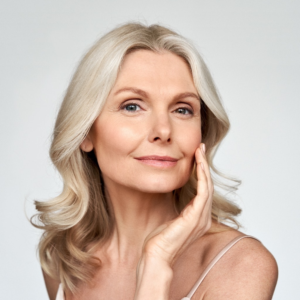 Beautiful gorgeous 50s mid aged mature woman looking at camera isolated on white. Mature old lady close up portrait. Healthy face skin care beauty, middle age skincare cosmetics, cosmetology concept